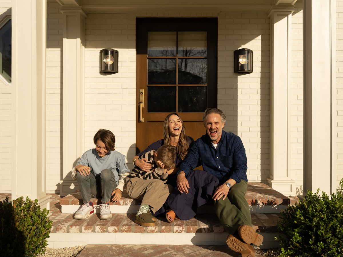 Happy family laughing on front porch of their new home